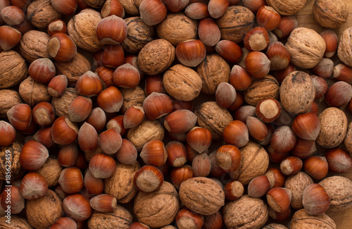walnuts and hazelnuts scattered on old, dark boards, background