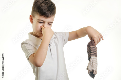 Картината върху платно Studio shot of young boy holding stinky sock