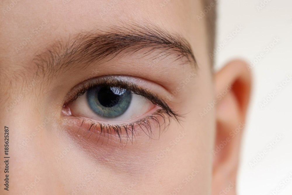 Fototapeta premium Close up view of a blue boy's eye looking at camera