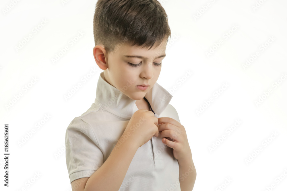 Studio shot of young boy buttonong his polo shirt Studio shot of young boy buttonong his polo shirt