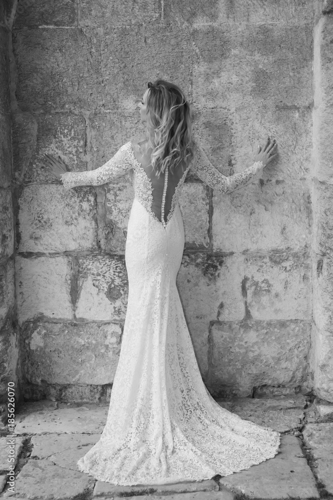 Beautiful bride in a white long dress in a city street