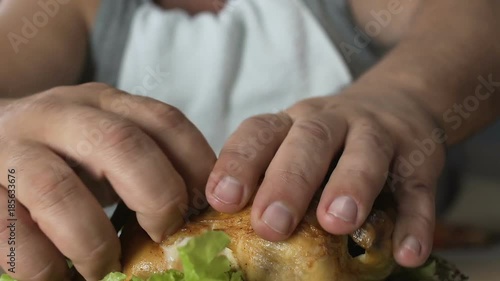 Hungry man eating chicken fast with hands, impoliteness in restaurant, addiction