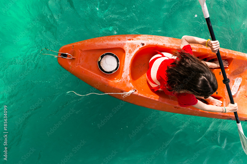 young woman girl in red bikini paddling on red, orange, yellow