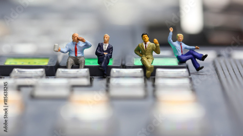 Miniature people : businessman sitting on switcher control of Television Broadcast,color buttons