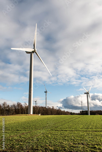 A panorama view over wind farm landscape in Germany with white generator turbines