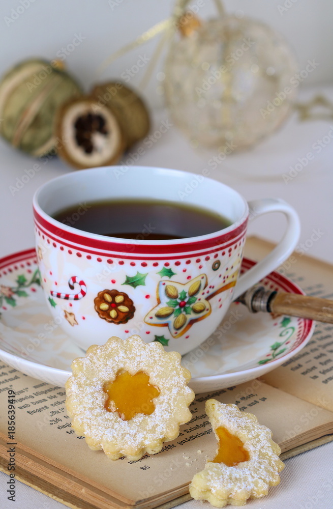 Weihnachtsplätzchen Spitzbuben und Teetasse mit Weihnachtsmotiv Weihnachtsplätzchen Spitzbuben und Teetasse mit Weihnachtsmotiv