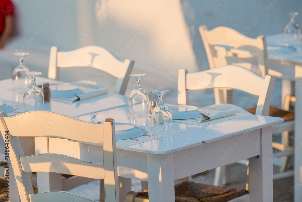 Outdoor cafe on a street of typical greek traditional village in Greece. Coffee on table for breakfast Outdoor cafe on a street of typical greek traditional village in Greece. Coffee on table for breakfast