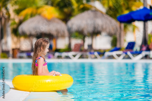 Little active adorable girl in outdoor swimming pool ready to swim