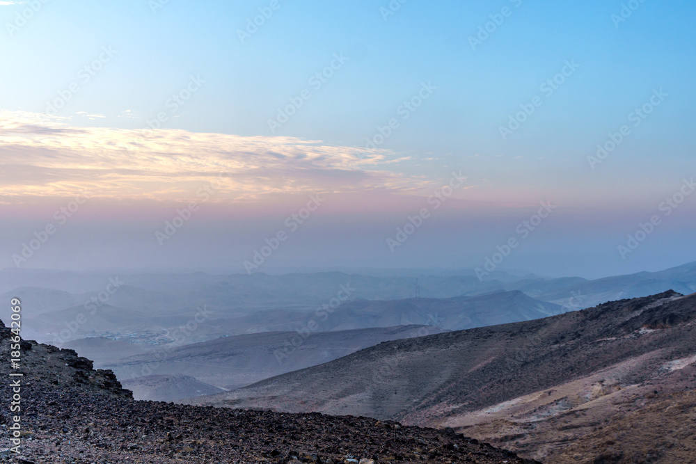 Colorful landscape view on judean desert with magic orange violet sky on background and color clouds.
