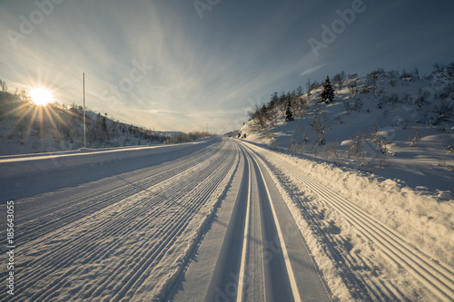The low sun shines on the freshly prepared ski tracks in the mountains in Setesdal, Norway