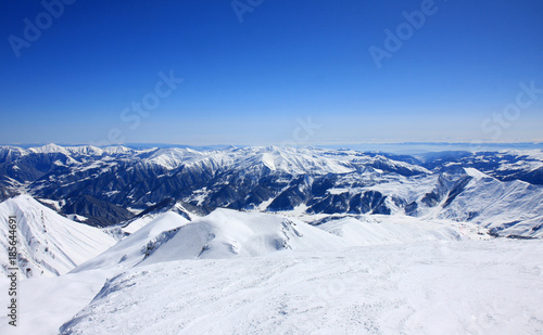 Georgia, mountains view with deep blue sky, white snowy landscape, picturesque scenery, ski resort in Caucasus, Gudauri © yanamavlyutova