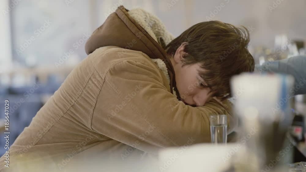 Tired young man drinks tequila at counter in bar 4K Tired young man drinks tequila at counter in bar 4K