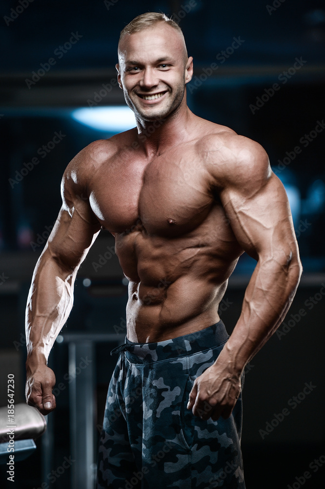 Brutal strong bodybuilder athletic men pumping up muscles with dumbbells. Brutal strong bodybuilder athletic men pumping up muscles with dumbbells.