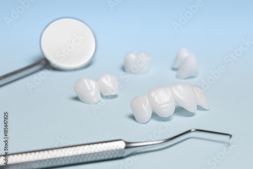Dental tools and dentures on a light blue background - Ceramic veneers - lumineers