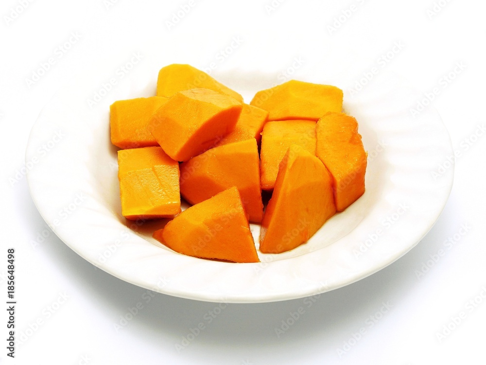 Cut papaya on white plate; white background. Deliciously sweet high fibre fruit; rich sources of antioxidant nutrients (carotenes, flavonoids, B and C vitamins, folate, minerals, etc.).