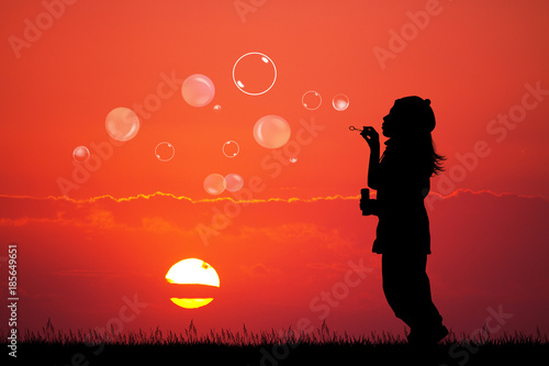 girl with soap bubbles at sunset