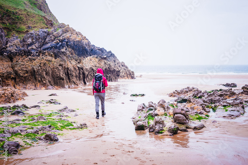 Woman Walking On The Rocky Beach In Rhossili Bay, Walesh Coast P photo