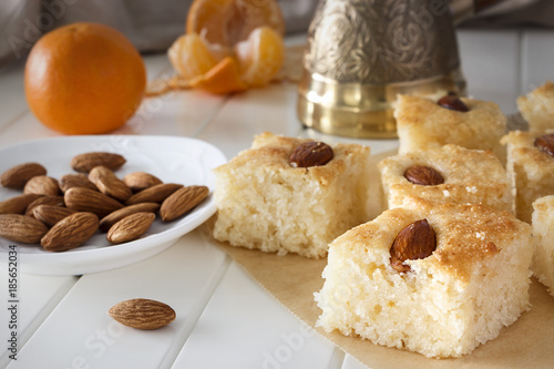 Pieces Basbousa (namoora) traditional arabic semolina cake with almond nut and syrup. Copy space.