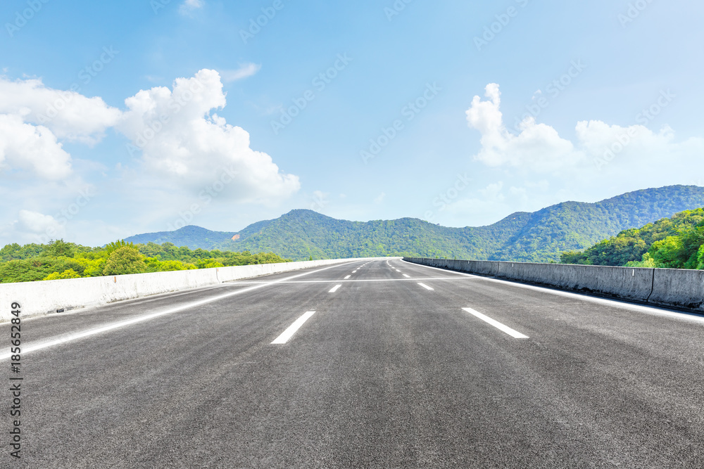 green mountain and empty asphalt highway natural scenery under the blue sky