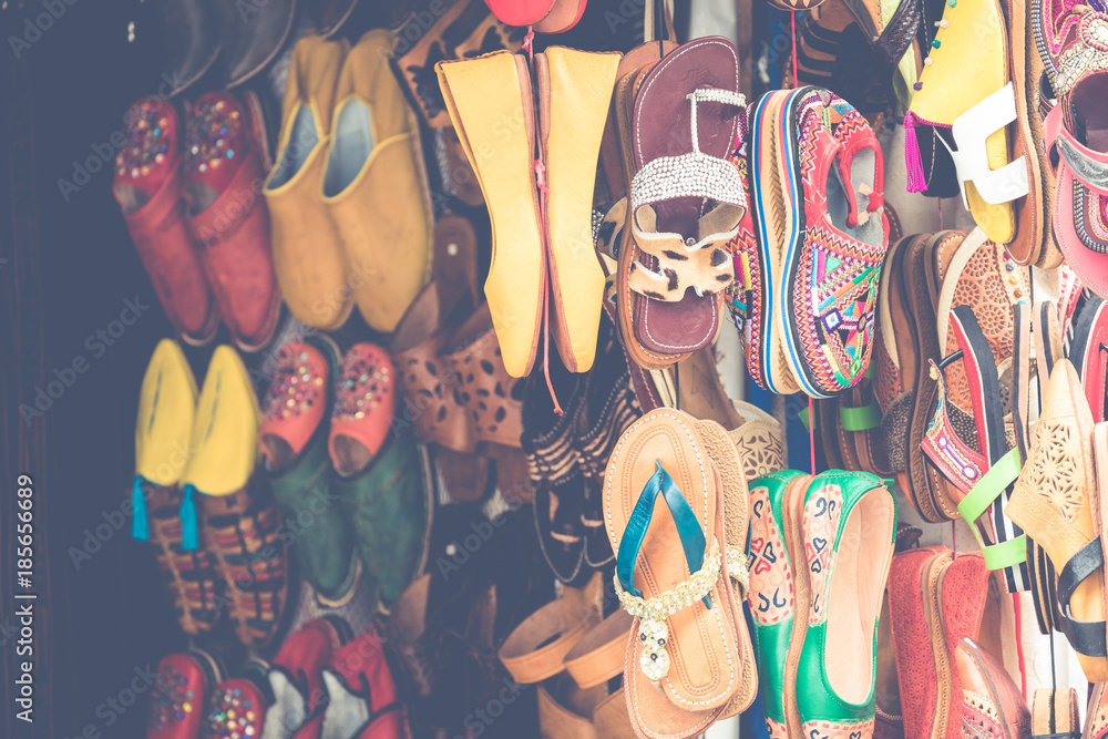 Moroccan leather goods bags and slippers at outdoor market in Marrakesh, Morocco.