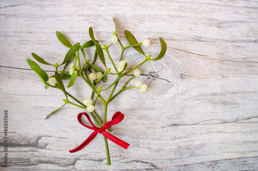 Christmas mistletoe decoration with red ribbon on wooden background. Christmas mistletoe decoration with red ribbon on wooden background.