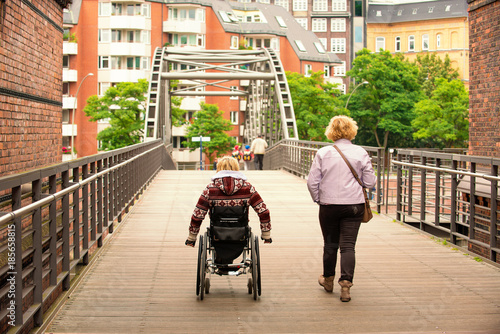 Disabled woman and woman go through the bridge