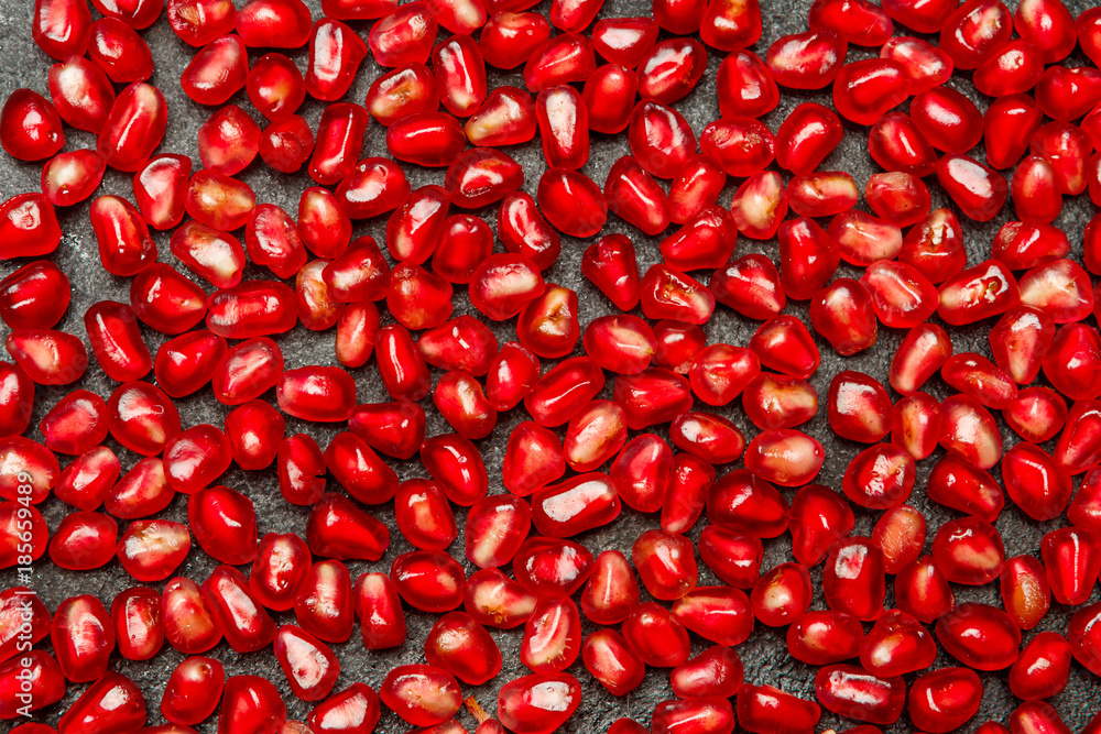 Pomegranate seeds close-up on dark concrete background Pomegranate seeds close-up on dark concrete background