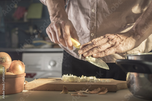 Man cuts onions in the kitchen