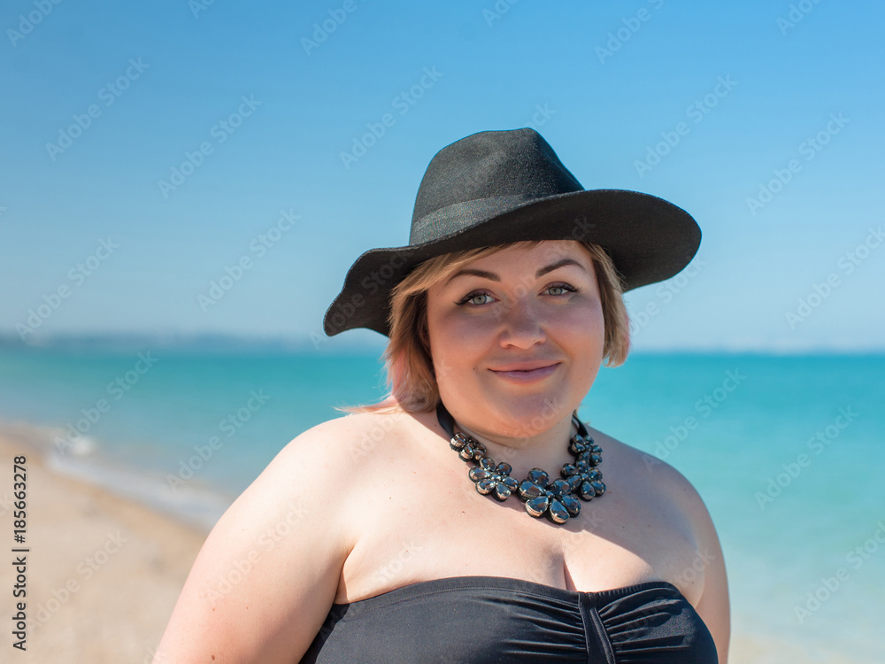 Portrait of overweight woman in hat and necklace at sea