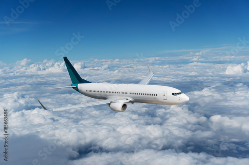 Commercial airplane flying above clouds and clear blue sky over beautiful scenery nature background,concept business travel and transportation background.