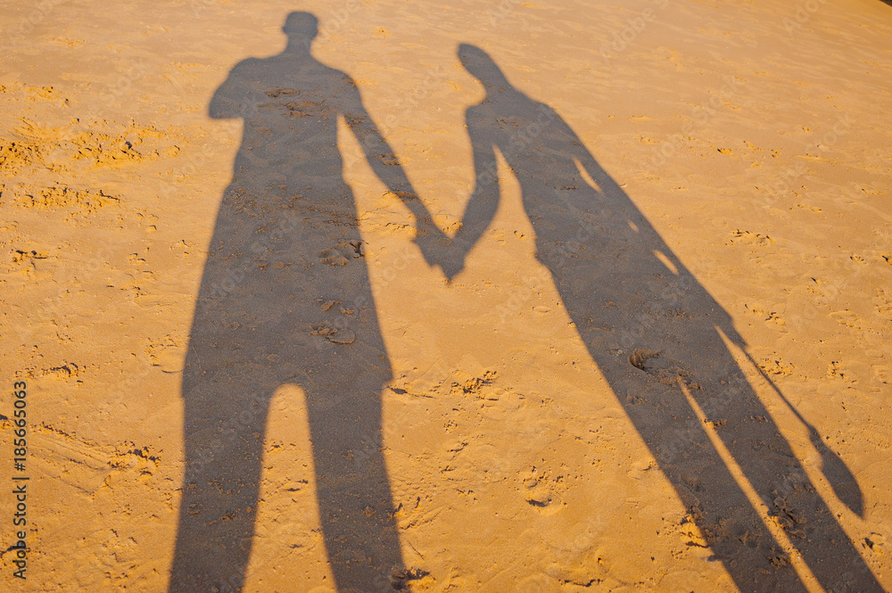 Portugal, Albufeira, portuguese beach with cliffs PRAIA DA GALA, couple hold hands shadow on sand