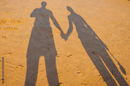 Obraz na płótnie Portugal, Albufeira, portuguese beach with cliffs PRAIA DA GALA, couple hold hands shadow on sand w salonie