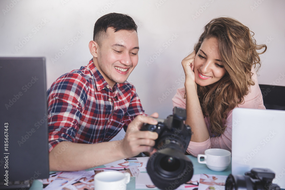 Fototapeta premium young photographer share the photo result with his model