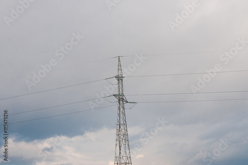 Electricity pylon on cold winter day, cloudy background with some blue sky.