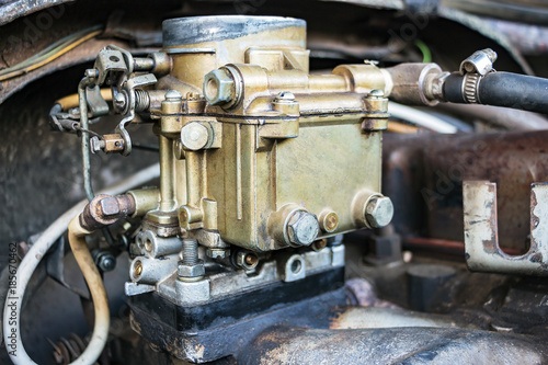 Spare parts of machinery. Vintage carb on the old engine