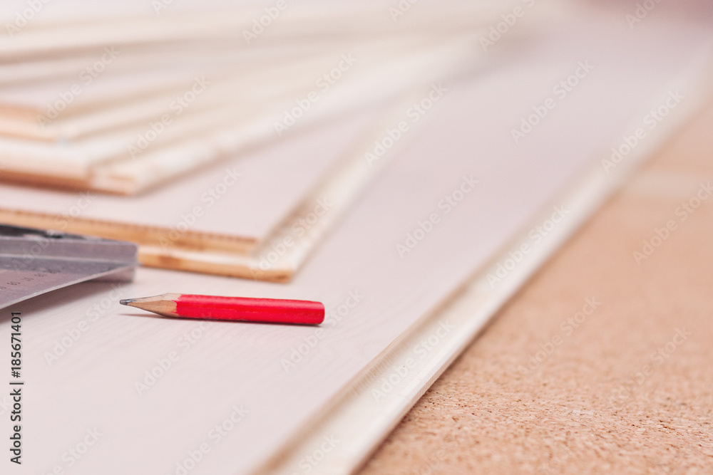Obraz premium Carpentry pencil and a square on the boards during work, carpentry work on the device of the floor, selective focus.