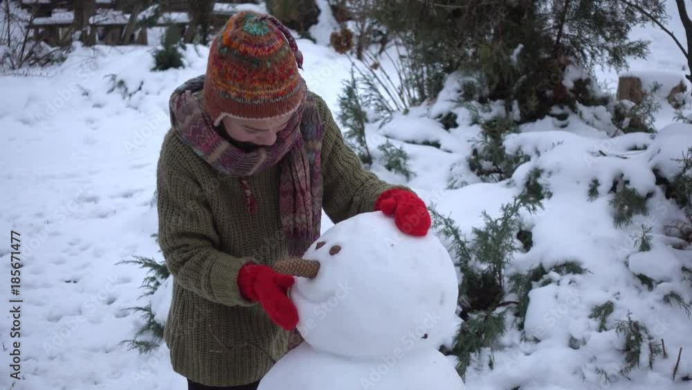 The boy is building a snowman in the garden. A child in the winter in the park sculpts a snowman.
The boy is building a snowman in the garden. A child in the winter in the park sculpts a snowman.
