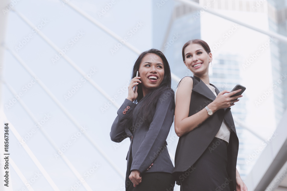 Two beautiful confident business woman talking on phone together. Two beautiful confident business woman talking on phone together.