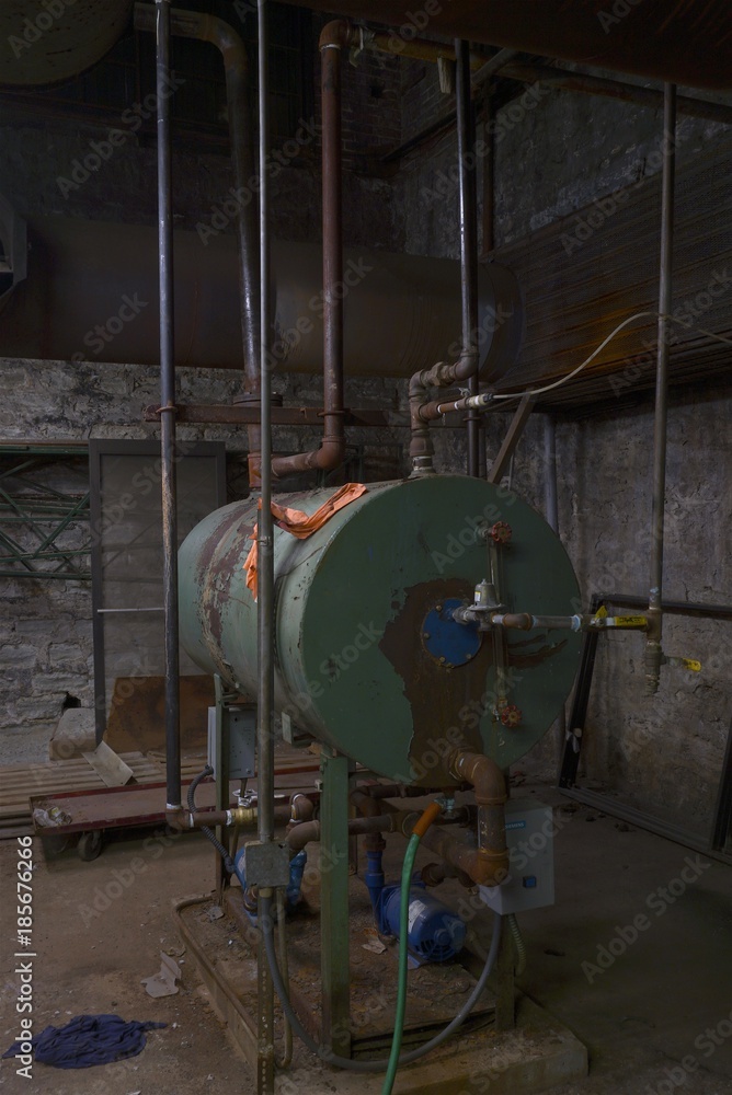 Old Boiler room in dirty old basement of warehouse building with rust and trash