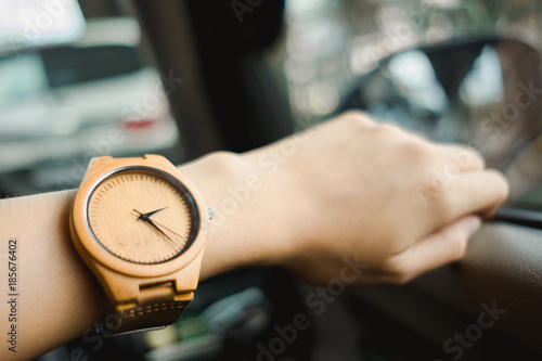 fashion background young business women wearing wooden watch and driving car. image for equipment, accessory, classic, transportation, body, vehicle concept
