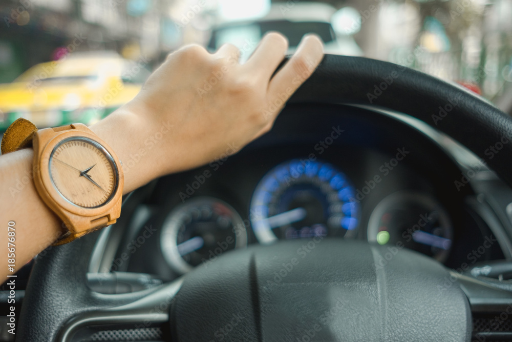 fashion background young business women wearing wooden watch and driving car. image for equipment, accessory, classic, transportation, body, vehicle concept
