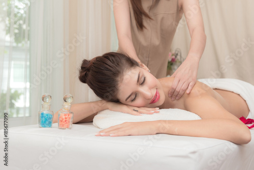 Asian exotic holiday spa concept. Beautiful young white woman enjoy relaxing during massage at spa, taken indoor in real spa location.