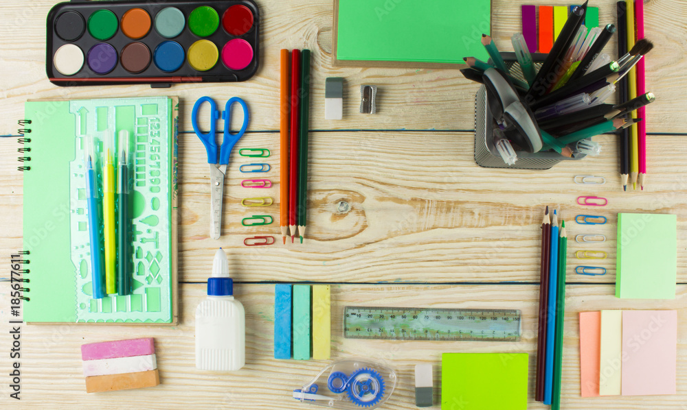Frame with school supplies on a wooden background. Flat lay, top view Frame with school supplies on a wooden background. Flat lay, top view