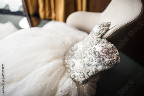 Fototapeta Naklejka Na Ścianę i Meble -  Wedding dress on the vintage chair, close-up