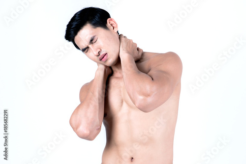 Fitness and health concept. Fit sport man having neck injury, isolated on white background in studio. Half naked Asian chinese lean muscular male wearing a black shorts.