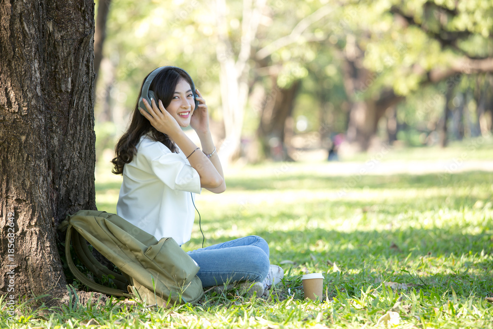 Asian Woman using Headset with attractive smiling at garden. People lifestyle concept. Asian Woman using Headset with attractive smiling at garden. People lifestyle concept.
