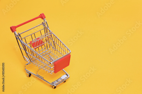 shopping trolley on yellow backgroud