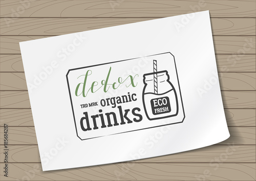 Badge in Frame Detox Organic Drinks with Hand Drawn Lettering and Jar Icon on A4 Sheet Paper on Wooden Background. Green Emblem Vector Illustration.