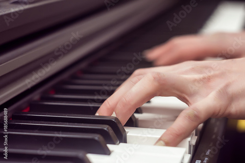 Closeup woman's hand playing piano. Favorite classical music. Top view with dark vignette