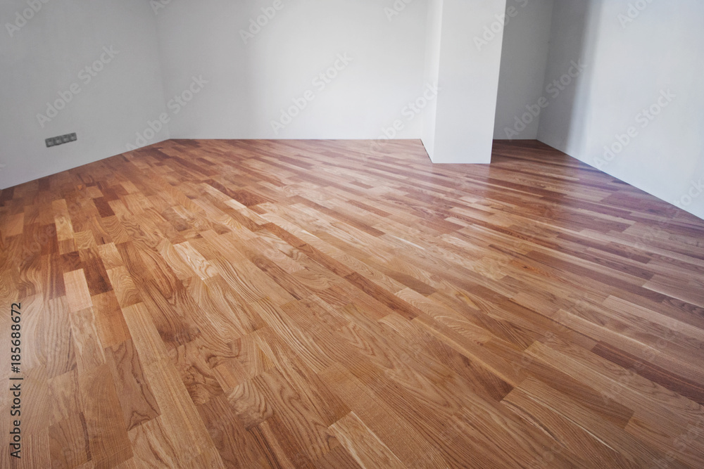 Flooring from a parquet oak board in an interior with bright light from a window. - obrazy, fototapety, plakaty 